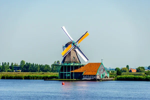 View from the Zaan River of a fully functional old Dutch Windmill at the Historic Village of Zaanse Schans in the Netherlands — Stock Photo, Image