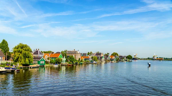 Вид с реки Заан на голландские ветряные мельницы и водохранилища в исторической деревне Заансе-Шанс и Заанди в Нидерландах — стоковое фото