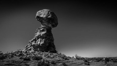 Dengeli Kaya 'nın Siyah ve Beyaz Fotoğrafı, Arches Ulusal Parkı, Moab, Utah, ABD' de çöl manzarasında uzun ve narin bir kum taşı oluşumu.