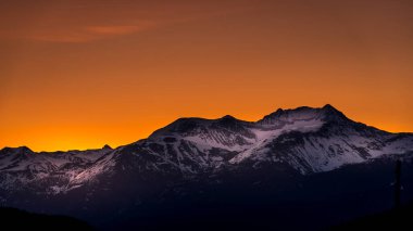 Sunrise over the Garibaldi Mountain Range with the northern most peak of Mt. Currie in the range in the distant. Viewed from Whistler RV Park plateau, British Columbia, Canada