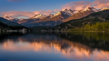 Sunset creating an Orange Sky over the Garibaldi Range and the Mountains Reflecting on the smooth surface of Green Lake near Whistler, British Columbia, Canada