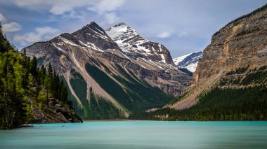 The silky looking turquoise water of Kinney Lake in Robson Provincial Park in the Canadian Rockies in British Columbia, Canada. Whitehorn Mountain and Cinnamon Peak in the background