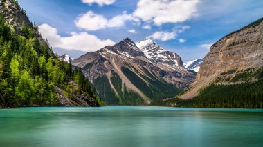 The silky looking turquoise water of Kinney Lake in Robson Provincial Park in the Canadian Rockies in British Columbia, Canada. Whitehorn Mountain and Cinnamon Peak in the background