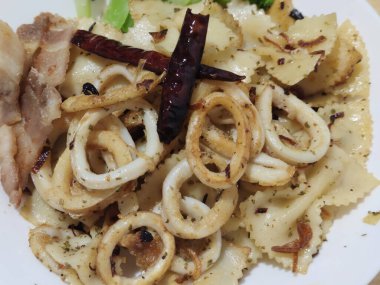 Kızarmış biberle süslenmiş ızgara kalamar halkaları taze brokoli ve yemek reklamı.