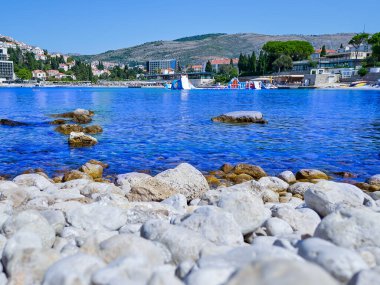 Dubrovnik kıyısındaki mavi berrak plaj. Temiz suyu olan taşlı plaj.