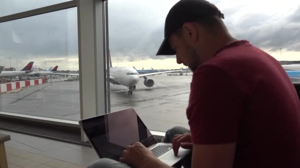 Man Writes Something Laptop Departure Hall Airport Planes Background Schiphol — Stock Video