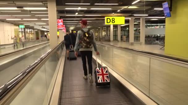 Los miembros de la tripulación de vuelo y los pasajeros utilizan escaleras mecánicas horizontales del aeropuerto. Schiphol Airport, Amsterdam, 15 de mayo de 2016 — Vídeo de stock