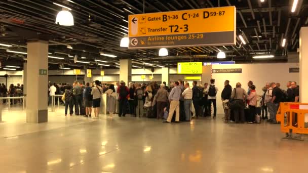 İnsanlar havaalanından ayrılmayı beklerken sırada bekliyorlar. Schiphol Airport, Amsterdam, 15 Mayıs 2016 — Stok video