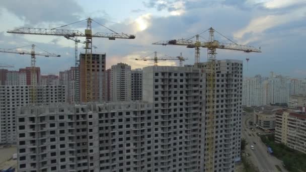 Aérien. Site de construction avec de nombreuses grues dans une grande ville. Heure du coucher du soleil — Video