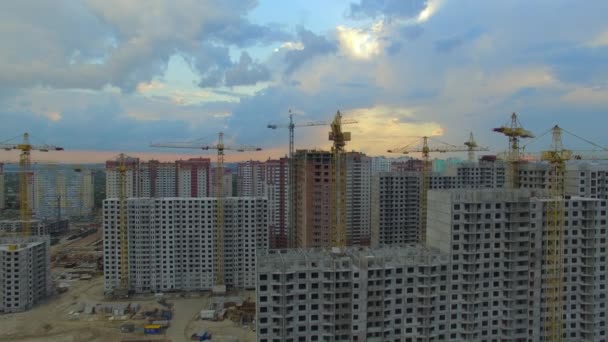 Aérea. Sitio de construcción con muchas grúas en una gran ciudad. Tiempo de puesta del sol — Vídeos de Stock
