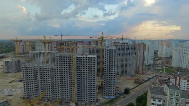 Aerial. Construction site with many cranes at a big city. Sunset time — Stock Video