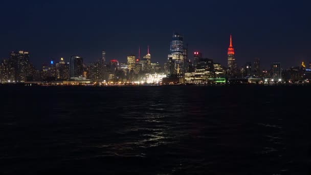 Lo skyline di New York di notte. Le luci della città si riflettono sull'acqua — Video Stock