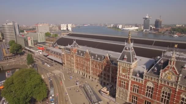 Осмотр достопримечательностей Амстердама с воздуха. Летаю рядом с центральным вокзалом. 4K — стоковое видео