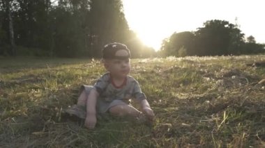 Yavaş çekim. Anne ve küçük çocuk çayırda oynuyorlar.