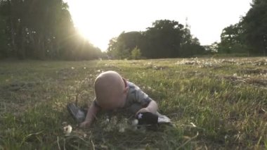 Yavaş çekim. Çayırda oynayan küçük çocuk