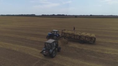 Ukrayna, 25 Ağustos 2020. Traktör, saman rulolarını toplar ve alana yükler