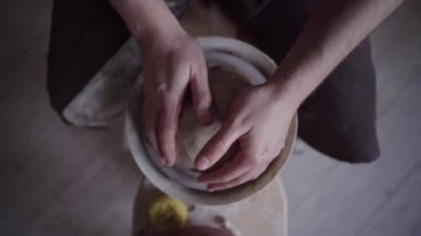 Seramik stüdyosu. Potter işte. Çamur kasesi çömlek çarkında dönüyor.