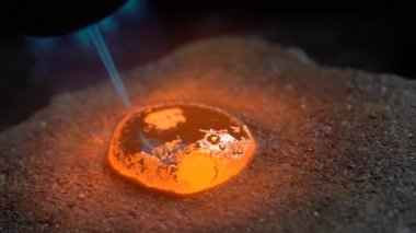 Gümüş damlası mücevher atölyesinde gaz ocağıyla eritilmiş. Kapat.
