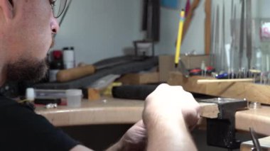 Kuyumcu kendi yarattığı yüzüğü parlatır..