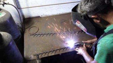 Kaynak işi yapan bir adam. Kaynakçı bir metali kaynaklıyor. 4K