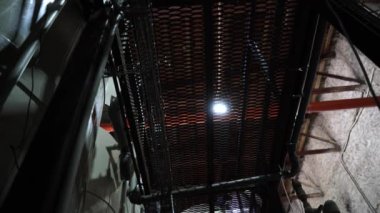 Fabrika merdivenlerinde yürüyen bir adam, alt manzara.