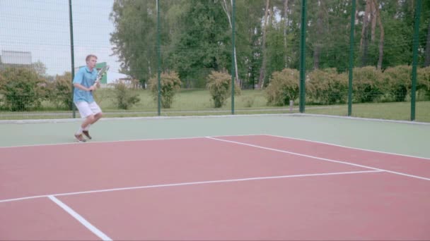 Jogador de tênis usa fatia backhand na metade do campo. Movimento lento — Vídeo de Stock