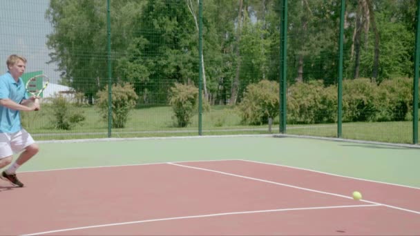 テニス選手は、半分裁判所のバックハンド スライスを使用します。スローモーション — ストック動画