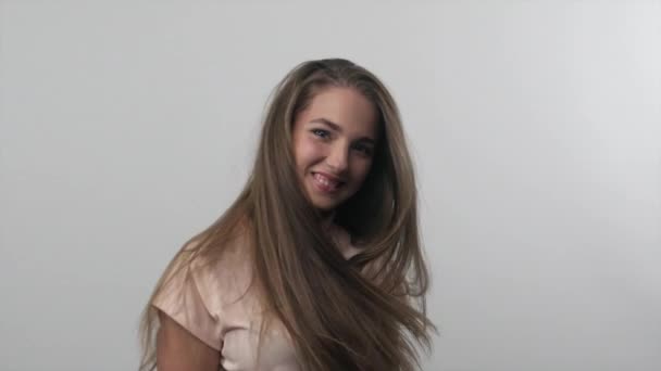 Chica joven jugando con su pelo largo y sonriente. Moción lenta — Vídeos de Stock