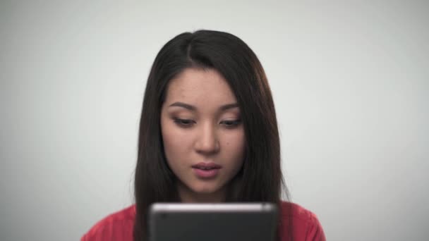 Retrato de chica asiática bonita usando tableta y sonriendo a la cámara — Vídeos de Stock