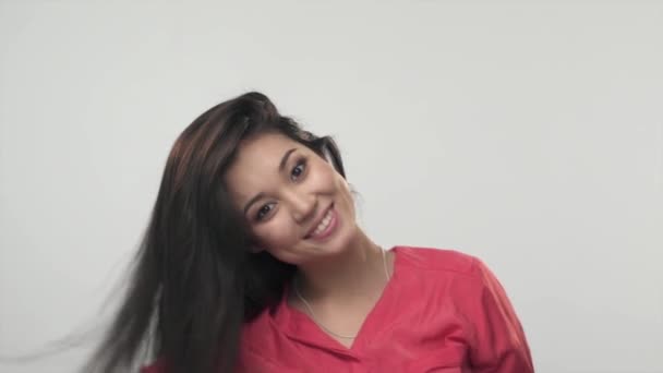 Brunette fille asiatique jouer avec ses cheveux longs et souriant. Mouvement lent — Video
