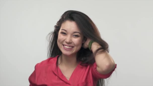 Brunette Asian girl playing with her long  hair and smiling.  Slow Motion — Stock Video