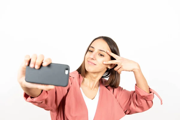 Junge Frau Macht Ein Selfie Vor Weißem Hintergrund — Stockfoto