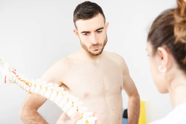 Shirtloze Atletische Patiënt Met Aandacht Voor Uitleg Van Een Fysiotherapeut — Stockfoto