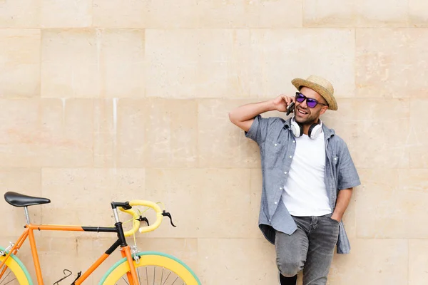 Hispanic Hipster Praten Zijn Telefoon Naast Een Kleurrijke Fiets Stedelijk — Stockfoto