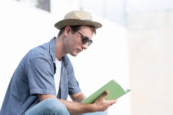一个正在看书的年轻人的衣服 大学生在户外学习 — 图库照片