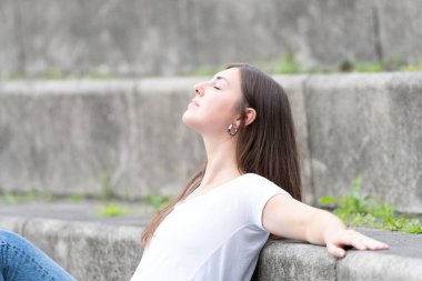 Güneş banyosu yapan ve dinlenen genç ve güzel bir kadının yakın çekimi.