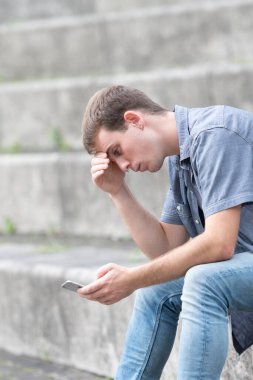 Genç adamın telefonunda kötü haberler var. Ruh sağlığı ve dijital bağımlılık kavramı