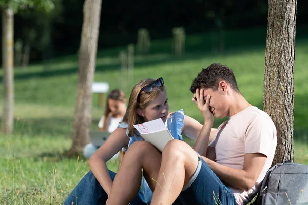 Frustrated student checking a failing grade exam. Teenager trying to cheer up her unsuccessful friend. University and academic failure concept.