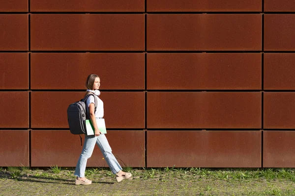 美しいですブロンド学生歩くと街の壁に沿って晴れた日に — ストック写真