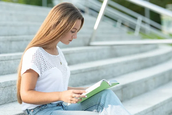 Hezký Student Dlouhými Blond Vlasy Sedí Schodech Čtení Knihy — Stock fotografie