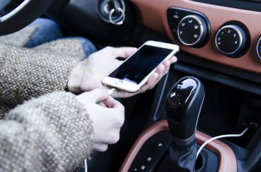  Araba tutmak içinde oturan bir Bayan smartphone beyaz ve takın 