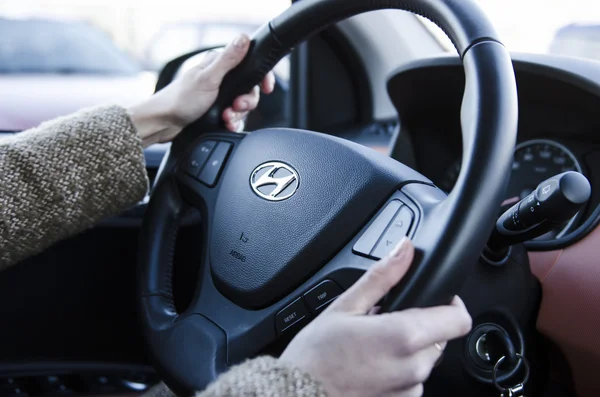 Hands holding steering wheel in hyundai car — Stock Photo, Image