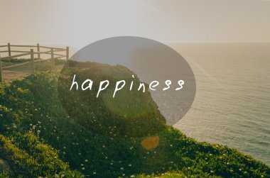 Güzel gün batımı görünümü çiçek ve Okyanusu yakınlarındaki ahşap çit ile yeşil dağ. Mutluluk işareti ile Oval Ekle