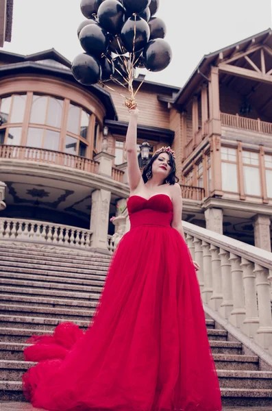 De jonge vrouw mooie mode in prachtige rode jurk en kroon — Stockfoto