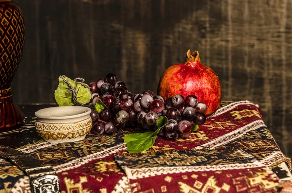 Natürmort şarap nar ve üzüm eski moda zemin üzerine
