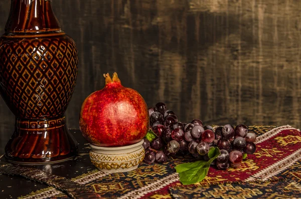 Natürmort şarap nar ve üzüm eski moda zemin üzerine