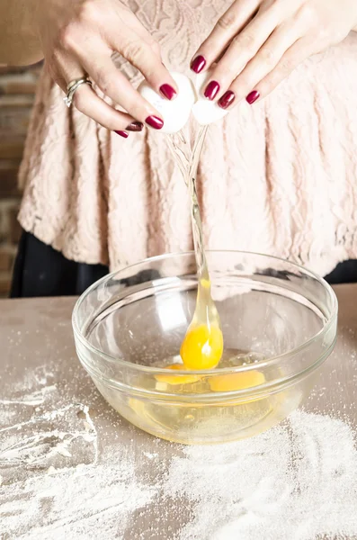 Woman in kitchen beating eggs — Stock Photo, Image