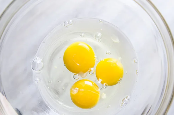 Ovos em tigela branca isolados na mesa da cozinha — Fotografia de Stock