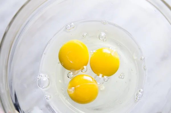 Eggs in white bowl isolated on kitchen table — Stock Photo, Image