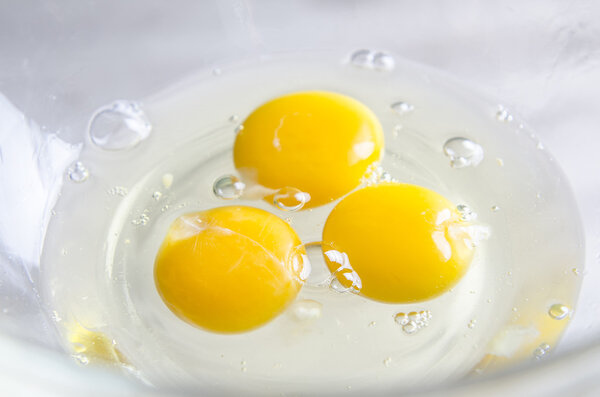 Eggs in white bowl isolated on kitchen table